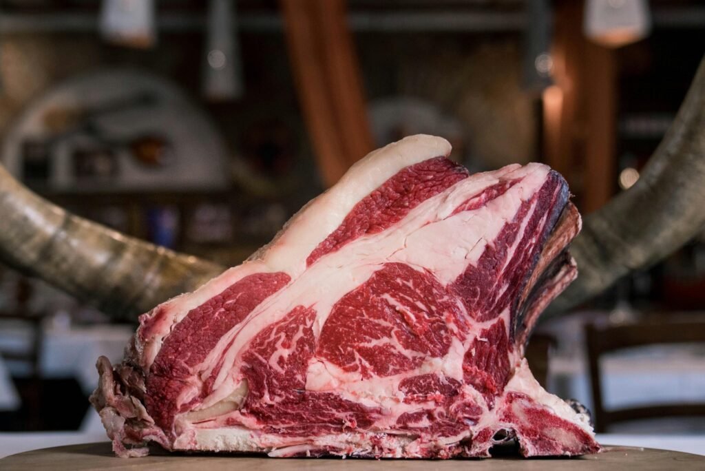 High-quality marbled beef rib displayed on a rustic wooden table, showcasing its raw texture and rich colors.